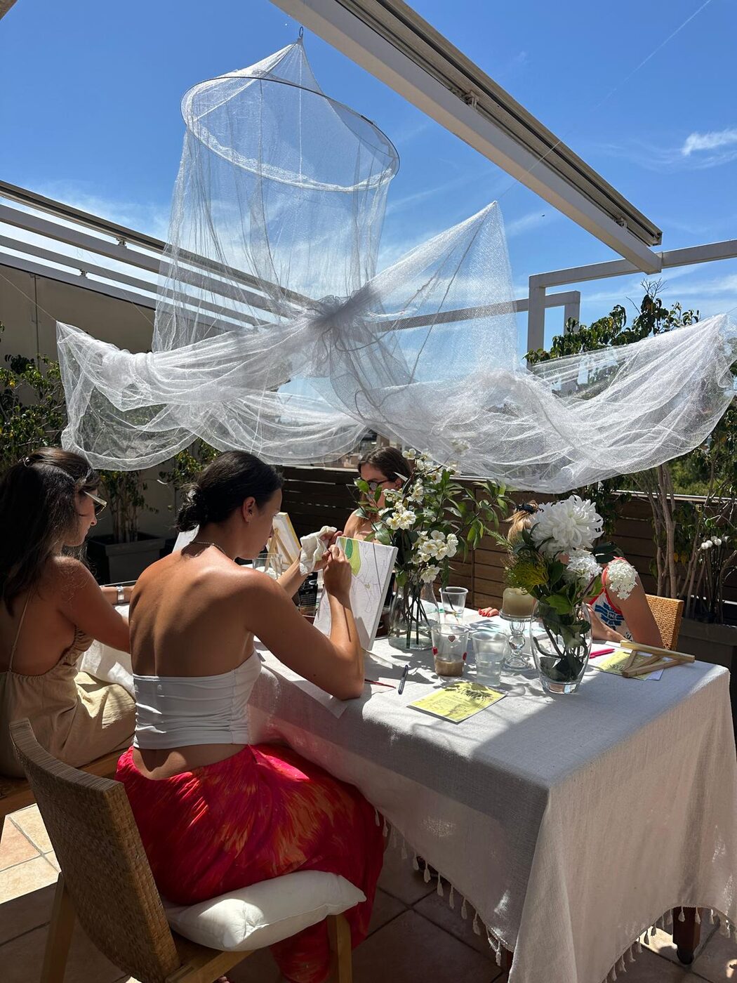A rooftop session beneath a flowing tulle canopy